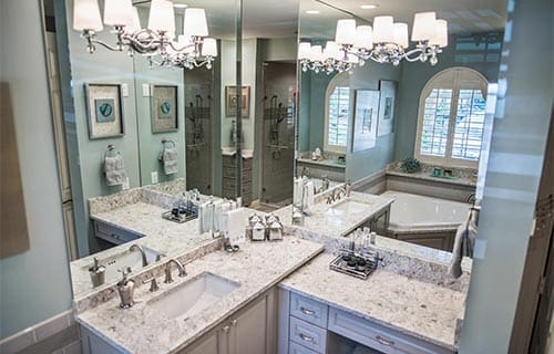 Modern luxury bathroom with granite countertops, double vanity mirrors, soaking tub, and walk-in shower