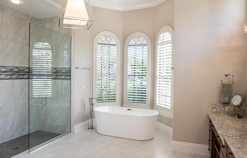 Spacious and modern bathroom with white bathtub and walk-in shower